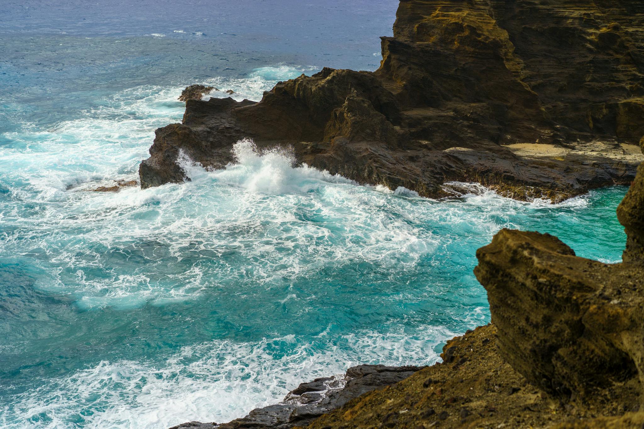 Dynamic seascape of ocean waves crashing against rugged coastal cliffs, showcasing nature's power.